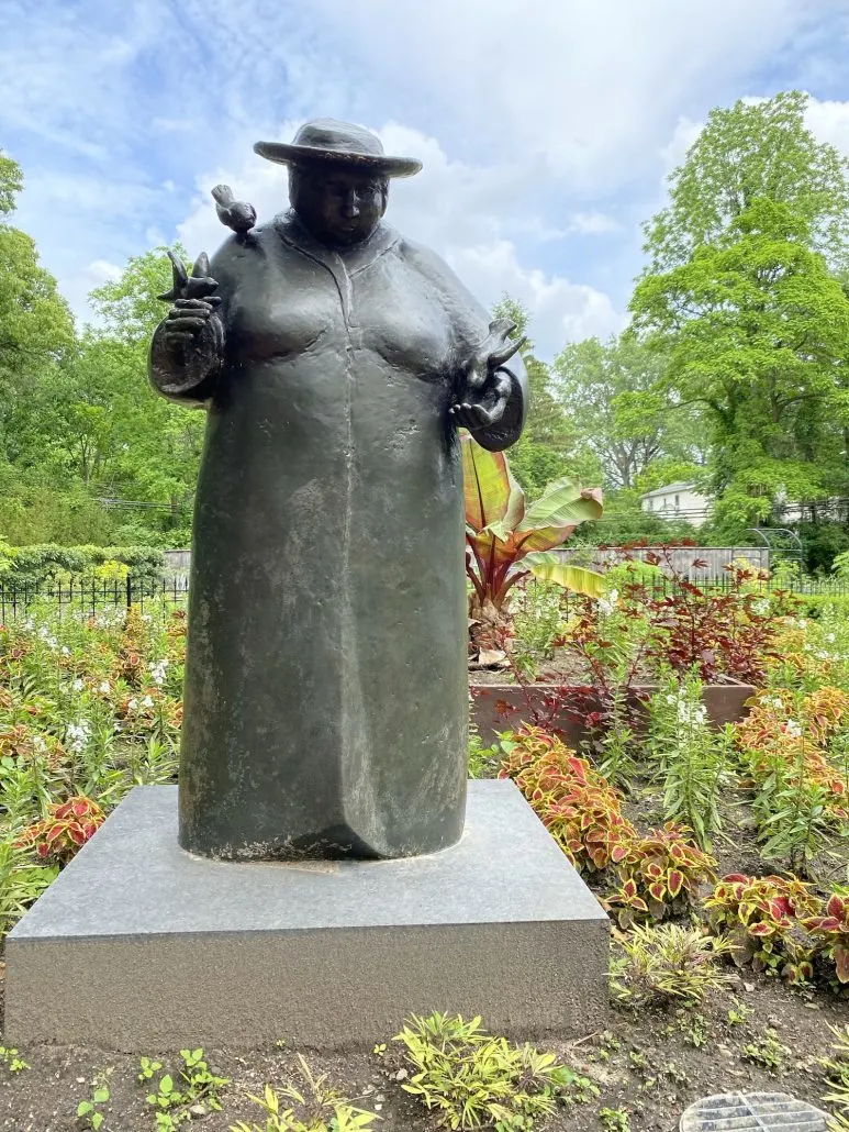 A statute of a woman holding birds at Toledo Botanical Garden in Ohio.
