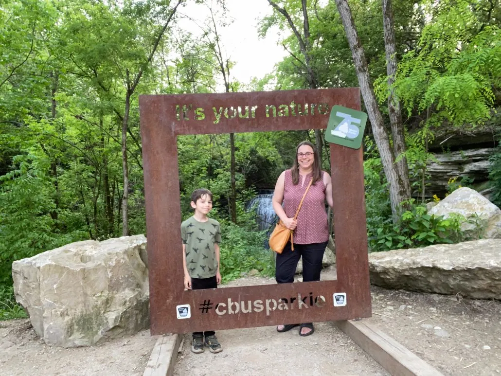 A mother and son posing for a picture in front of Millikin Falls.