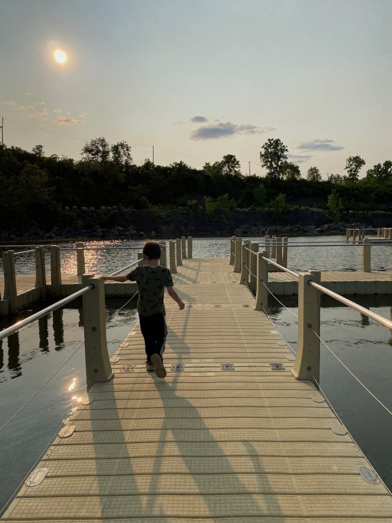 A boy walking on the floating boardwalk at Quarry Trails.