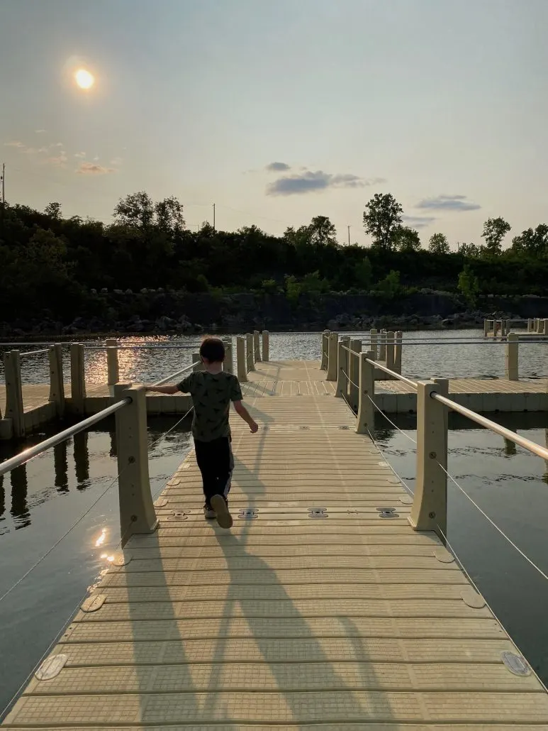 A boy walking on the floating boardwalk at Quarry Trails.