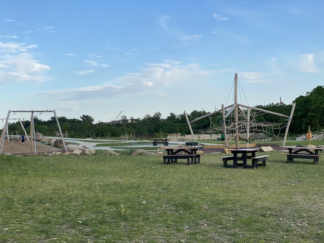 Zipline, climbing structure and picnic tables within the park.
