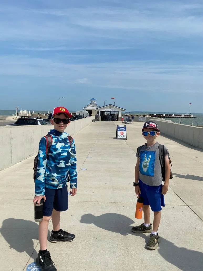 Two boys standing in front of the Miller Ferry dock on Put-in-Bay.