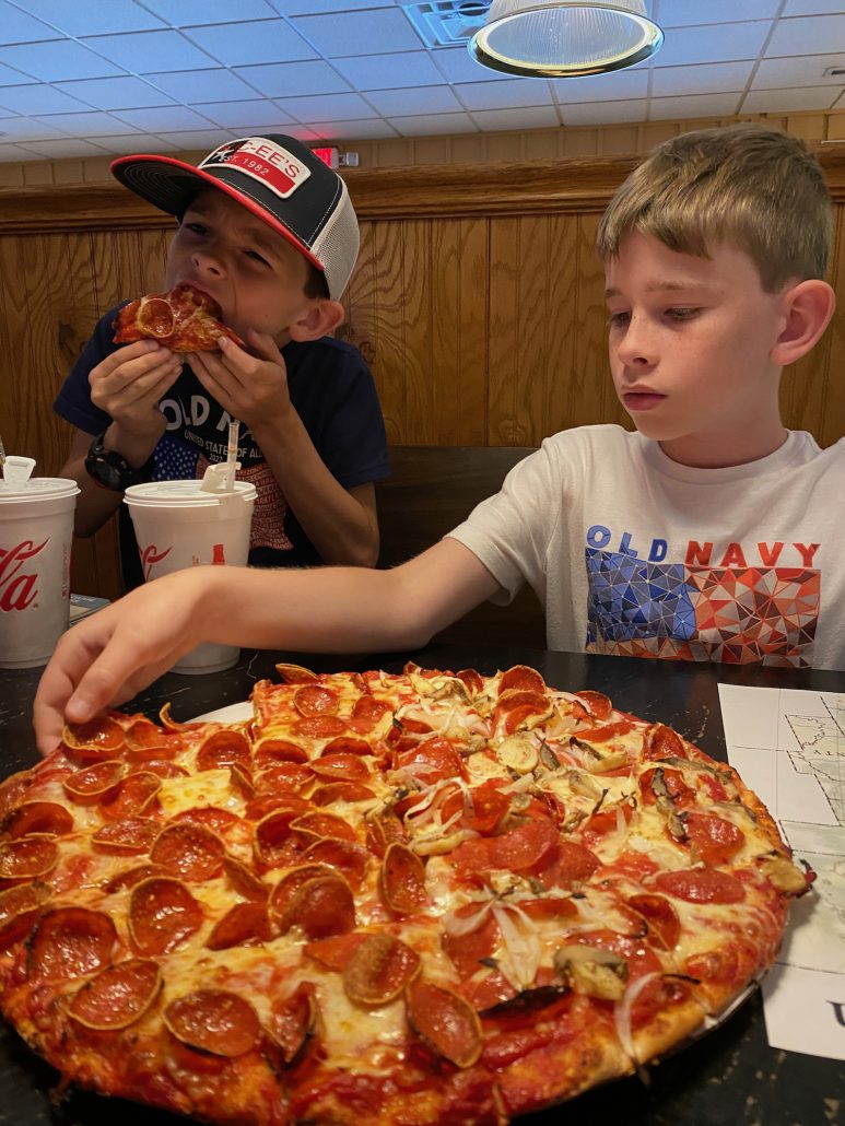 Two boys eating pizza at Pizza Crossing in Logan, Ohio.