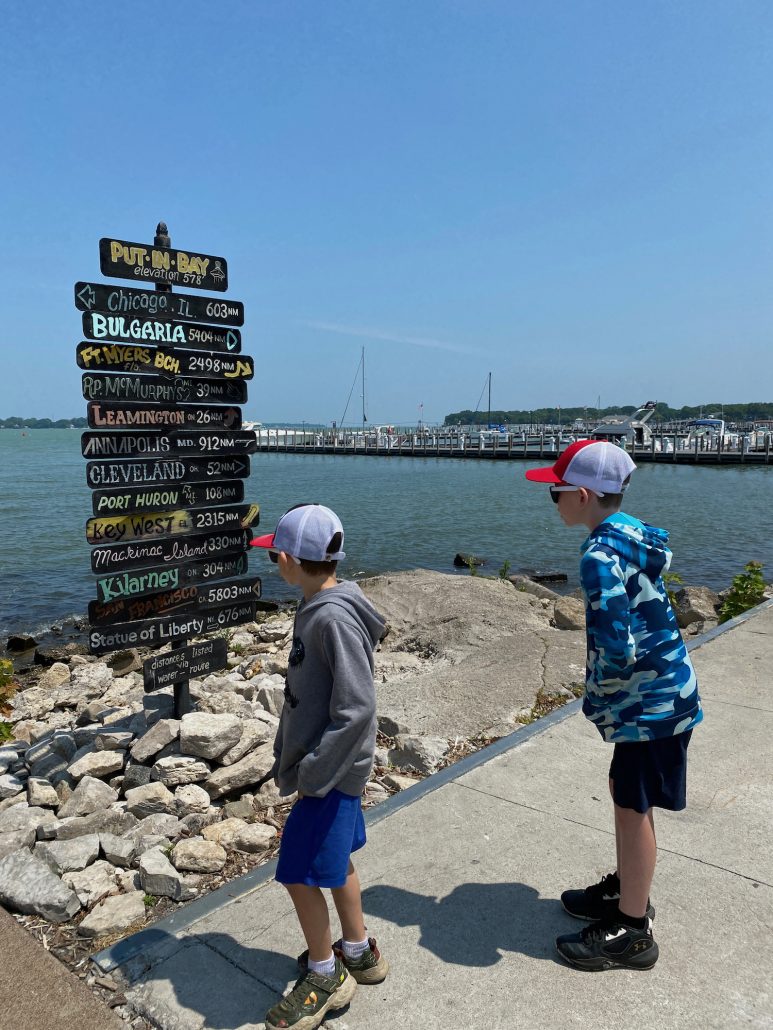 Two boys in front of a sign at Put-in-Bay Island in Ohio.
