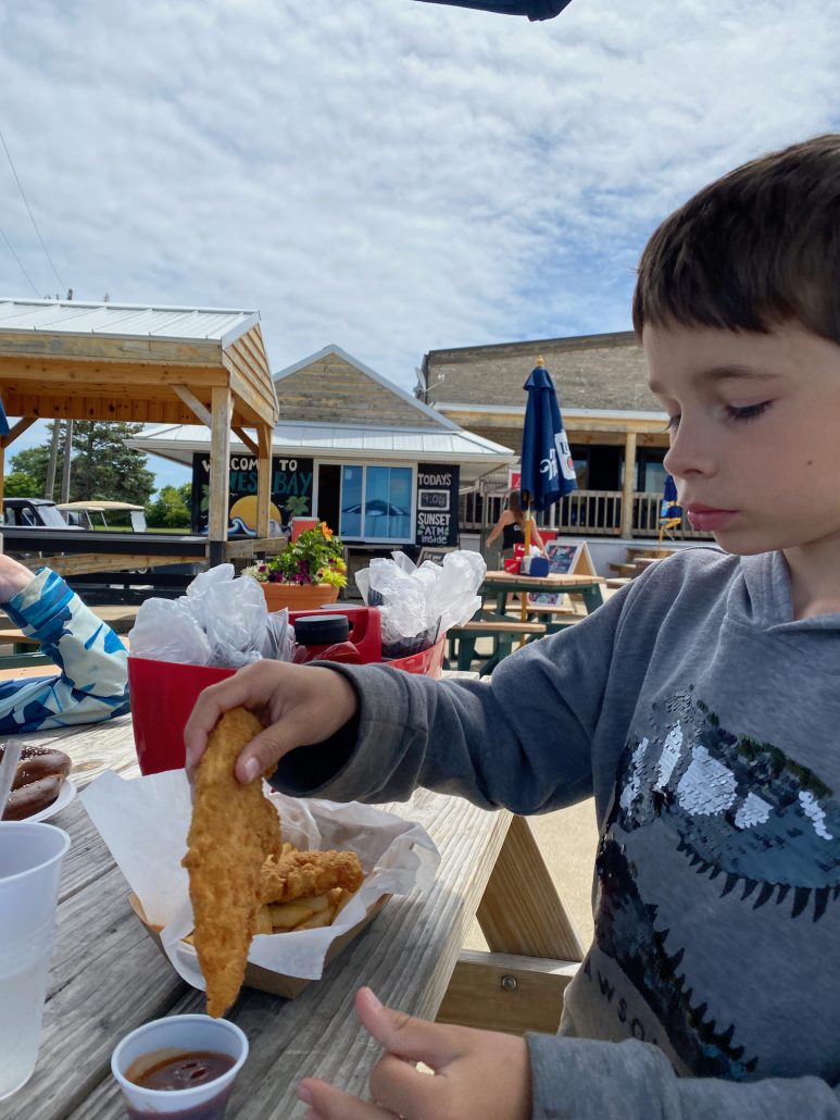 A boy eating chicken fingers at West Bay Inn.