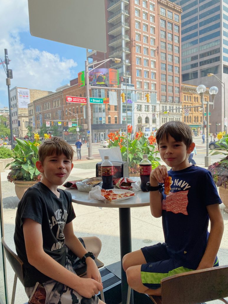 Two boys eating pizza at a restaurant in downtown Columbus, Ohio.