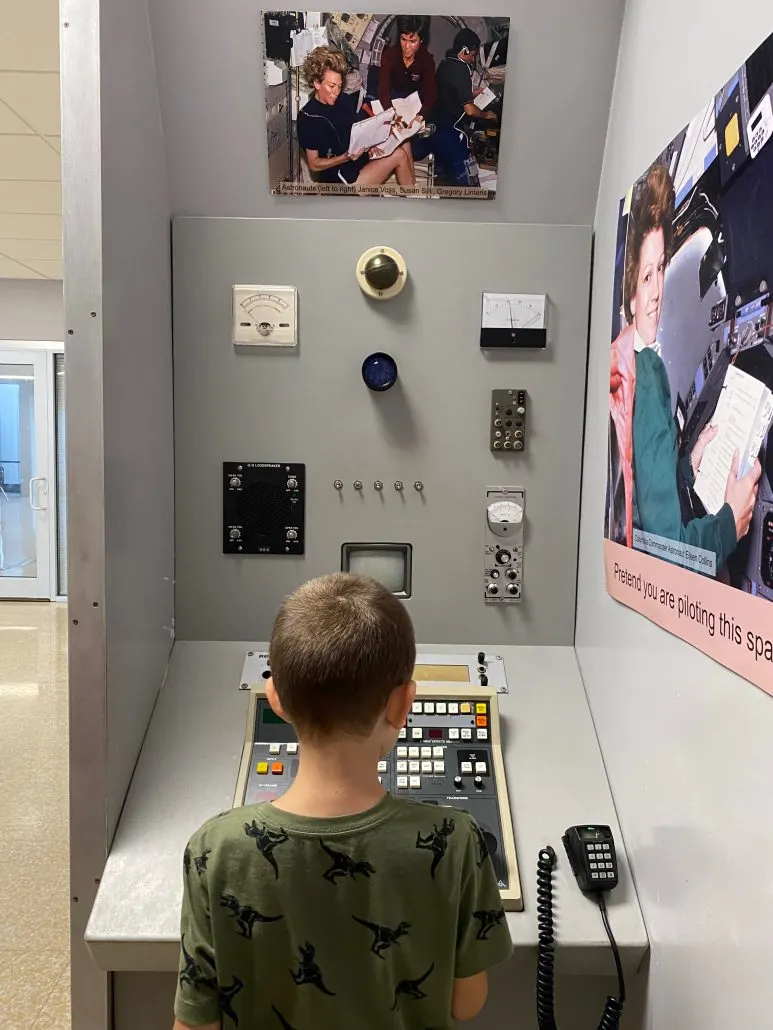 A boy interacting with a museum display at the Burke Lakefront Airport in Cleveland.