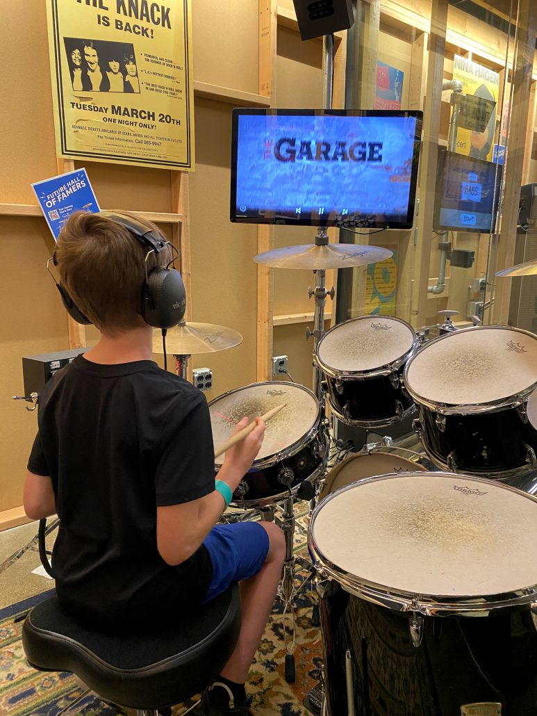 A boy playing the drums in The Garage at the Rock and Roll Hall of Fame in Cleveland, Ohio.