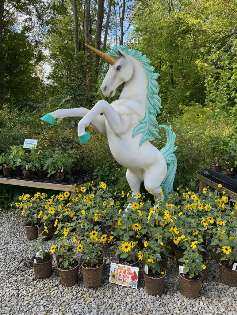 A unicorn statue surrounded by flowers.