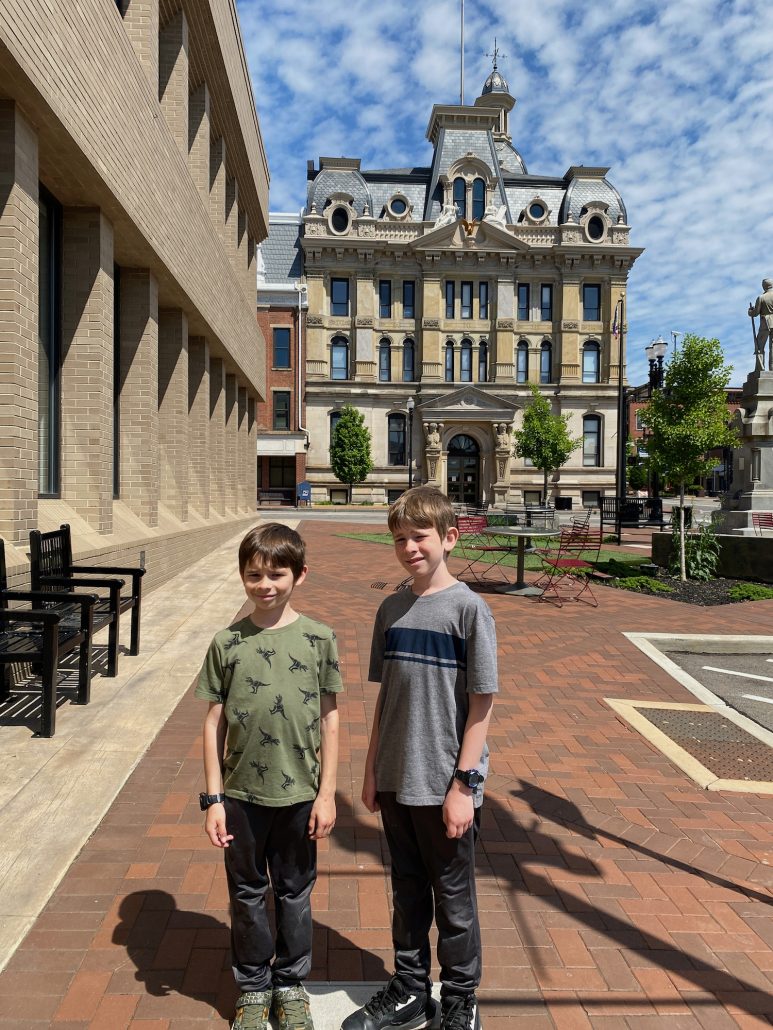 Two boys standing in front of the Wayne County Courthouse in downtown Wooster.
