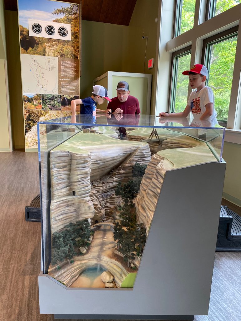 Dad and two boys looking at a display of Old Man's Cave at the Hocking Hills Visitors Center.