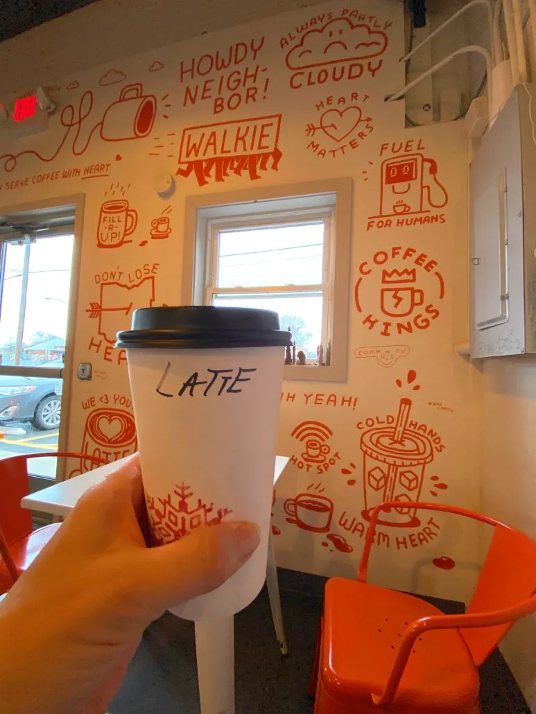 A cup of coffee in front of a decorated wall at Walkie Talkie Coffee shop in Canton, Ohio.