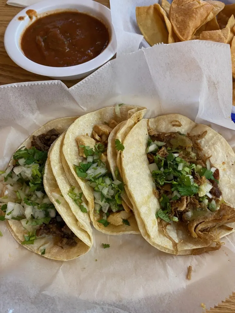A plate of tacos with chips and salsa at El Rancherito Taqueria.