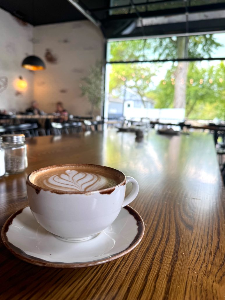 A latte in front of the open garage door at Red Hen Cafe.