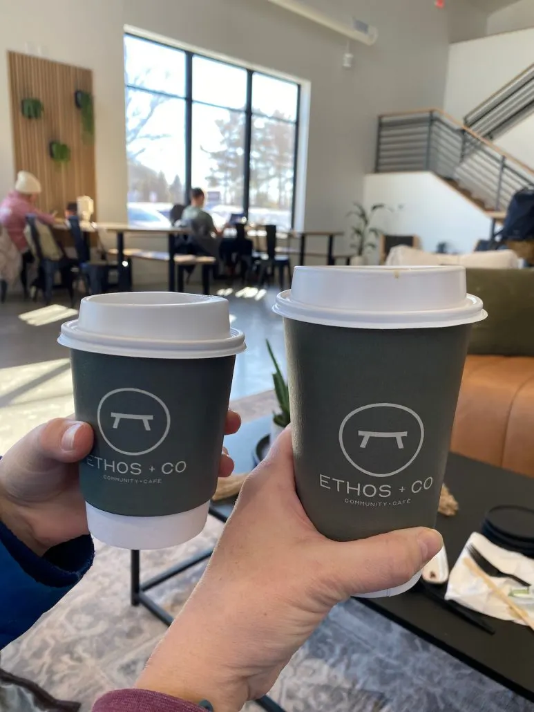 Two coffee cups inside Ethos + Co Cafe.