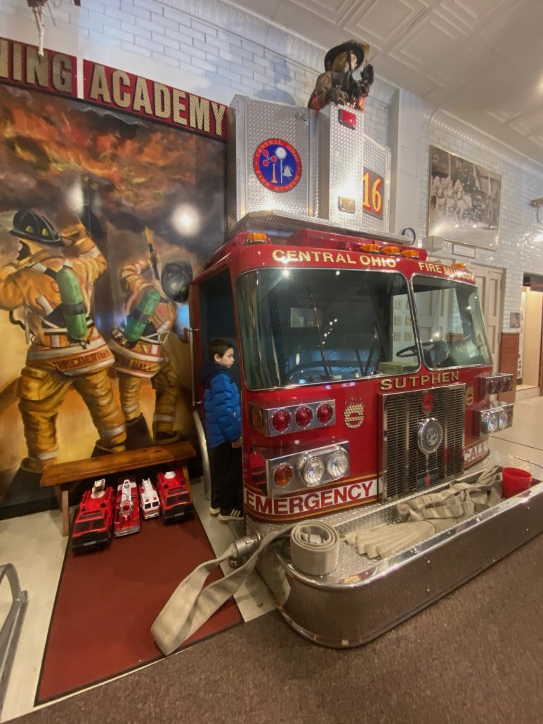 A boy entering a fire truck play area at the Central Ohio Fire Truck Museum.