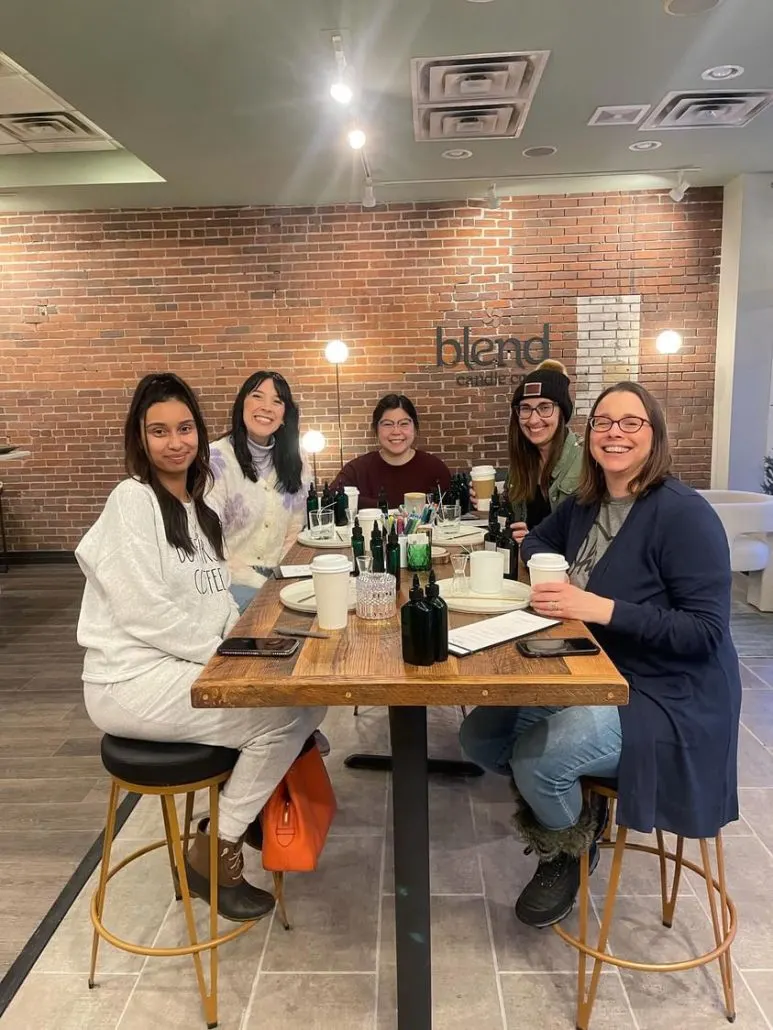 5 women seated at a table making candles at Blend Candle Co in Uptown Westerville, Ohio.