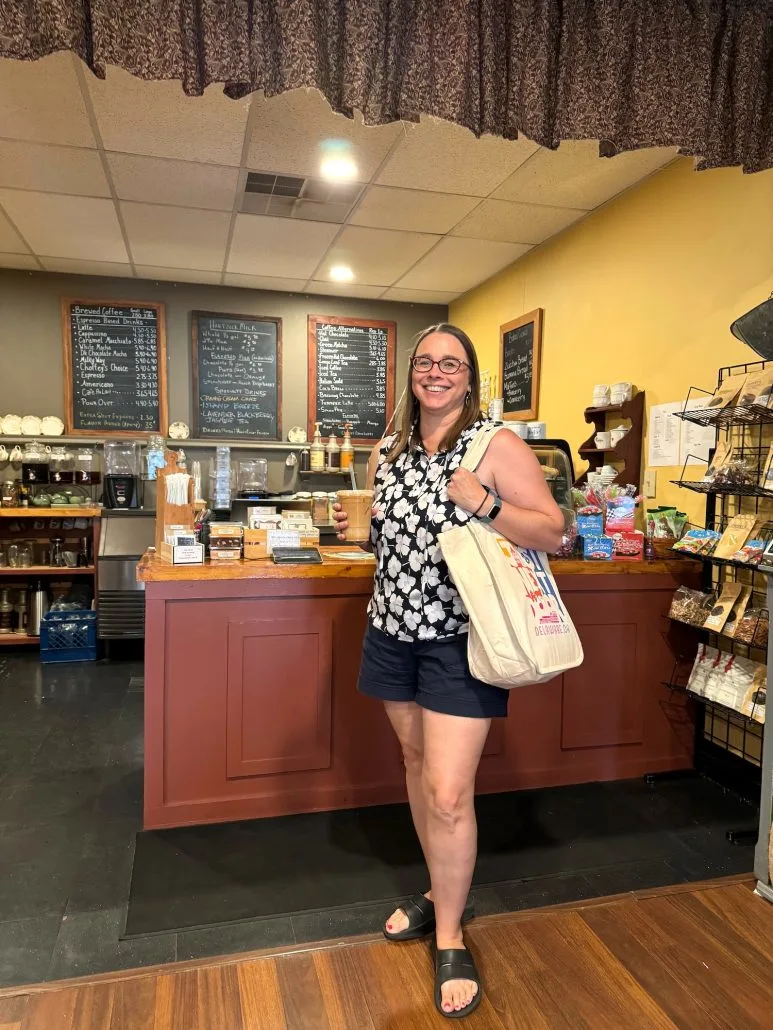 A woman holding an iced latte at Choffeey's Coffee & Confections.