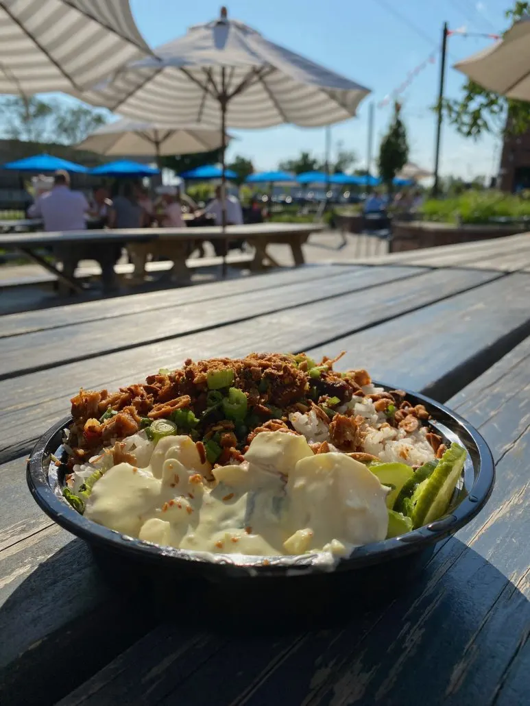 A bowl of food on a picnic table on the patio at Center Street Market.