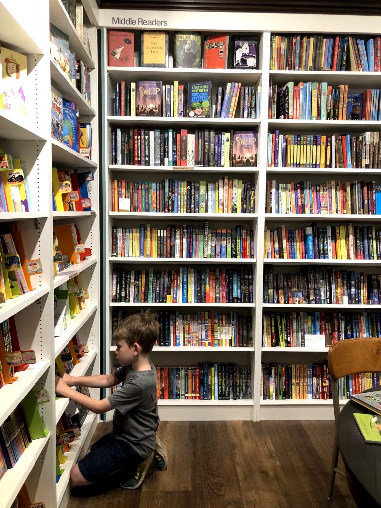 A boy looking for books at Cover to Cover Books for Young Readers.