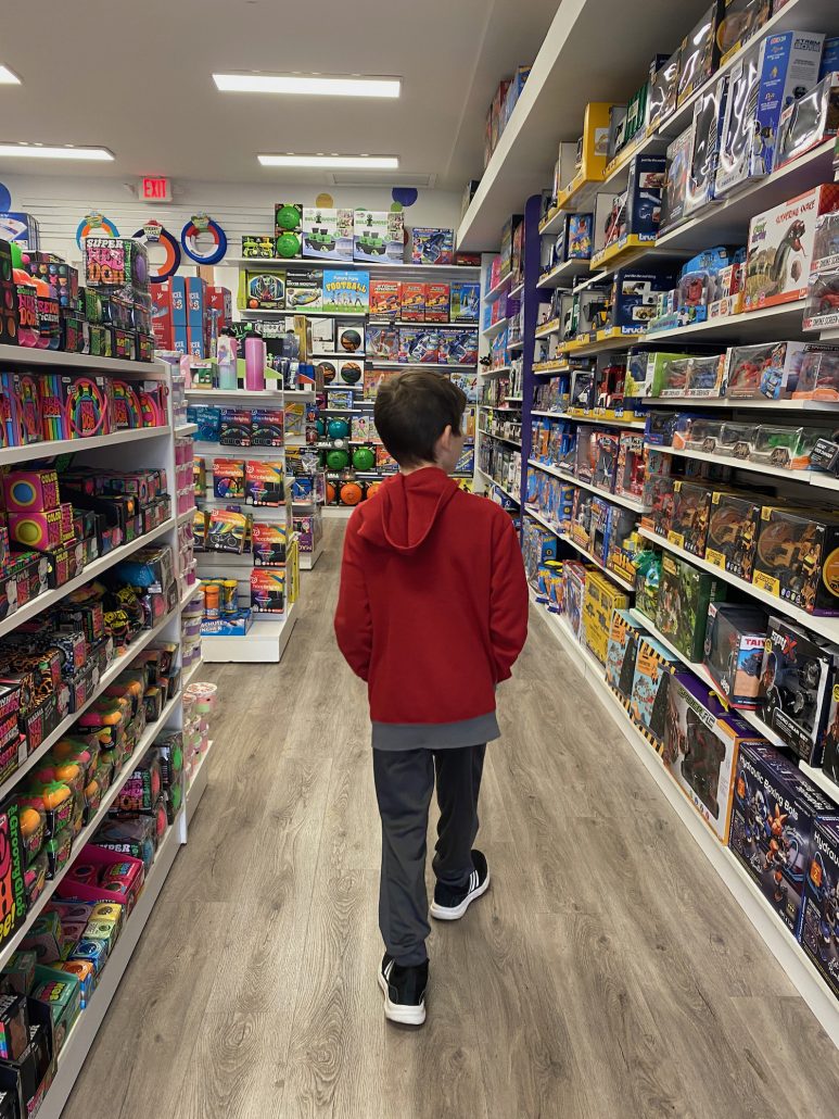 A boy walking through the toy store Learning Express.