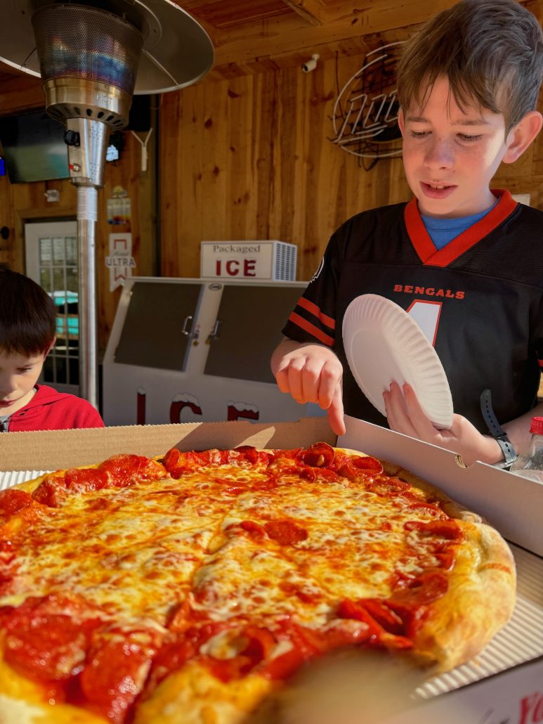 A boy picking out a piece of pizza at Papa Dino's in Hocking Hills.