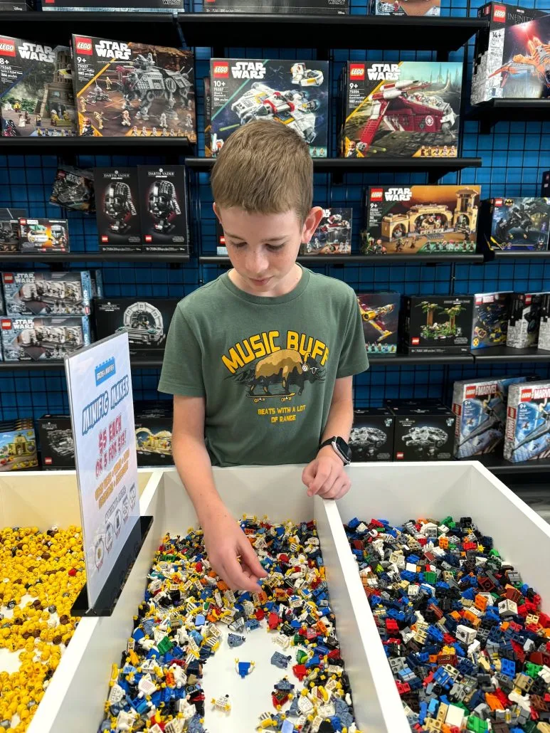 A boy building his own Minifig at BAM Powell.