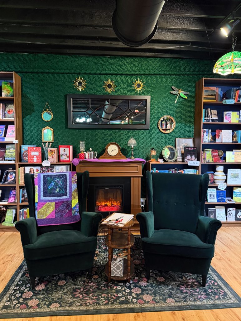 A seating area with two chairs and a fireplace at Dragonfly Bookshop in Hilliard.
